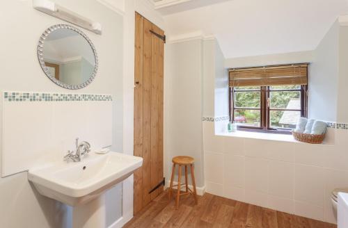 a bathroom with a sink and a mirror at Hedgehog Cottage Wheddon Cross in Wheddon Cross