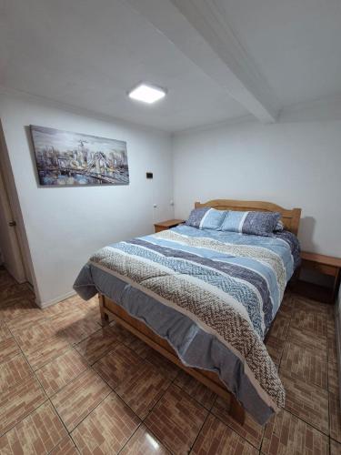 a bedroom with a bed and a painting on the wall at Mini departamento independiente in Antofagasta