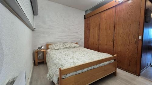 - une petite chambre avec un lit et un mur en bois dans l'établissement Appartement T2 vue sur mer, à Saint Cyprien Plage