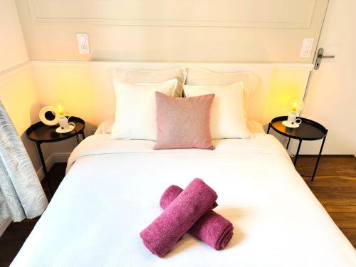 - un lit blanc avec 2 serviettes violettes dans l'établissement L'Orange Serenity - Parking - Gare à 5 min, à Troyes