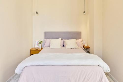 a bedroom with a large bed with white sheets and pillows at Citizentral Juristas in Valencia