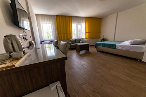 a hotel room with a bed and a kitchen with a sink at Şirin Apartrooms in Pamukkale