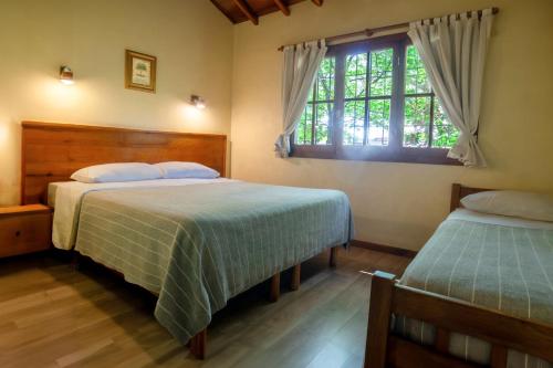 a bedroom with two beds and a window at Hotel Turismo in San Martín de los Andes