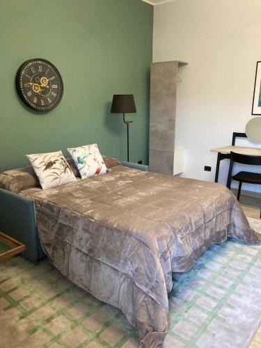 a bedroom with a large bed with a clock on the wall at B&B La Perla in Frosinone