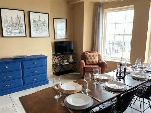 a dining room with a table and a blue dresser at Georgian Townhouse on the beach in Worthing