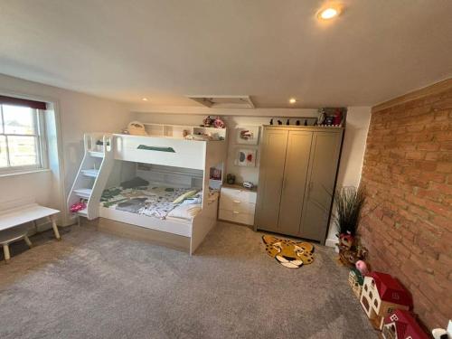 a bedroom with a bunk bed and a brick wall at Georgian Townhouse on the beach in Worthing