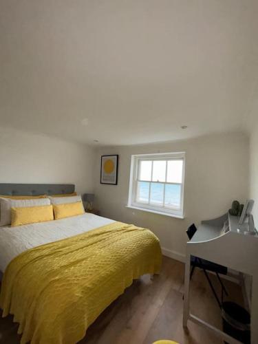 a bedroom with a bed and a desk and a window at Georgian Townhouse on the beach in Worthing