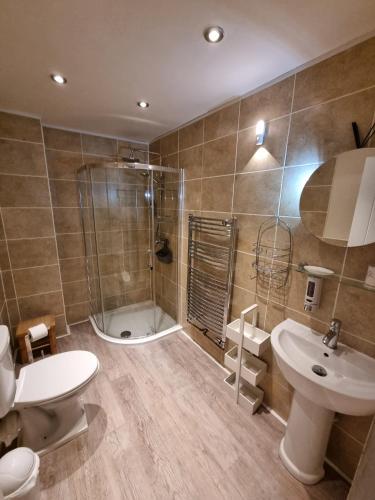 a bathroom with a shower and a toilet and a sink at Anchor House 2 East Street Alford Lincolnshire LN13 9EQ in Alford