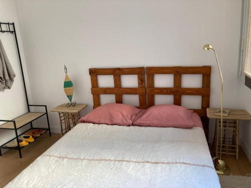 - une chambre avec un lit et 2 oreillers roses dans l'établissement Appartement d'architecte, à Marseille