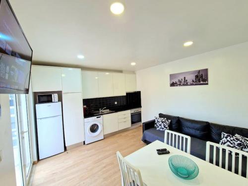 a kitchen and living room with a table and a couch at Casa da Tojeira in Casal de Pianos