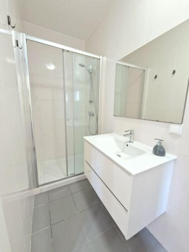 a white bathroom with a sink and a shower at Casa da Tojeira in Casal de Pianos