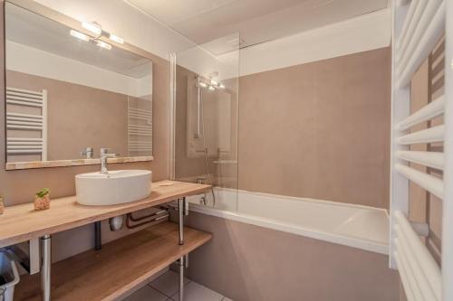 une salle de bain avec un lavabo et une baignoire dans l'établissement BIARRITZ GRANDE PLAGE - STUDIO AVEC BALCON - Victoria Surf, à Biarritz