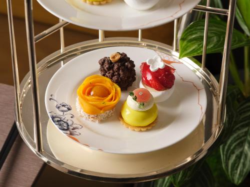 a group of desserts on a plate on a shelf at Pan Pacific London in London