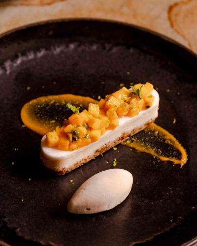 a piece of food on a black plate with a spoon at Pan Pacific London in London