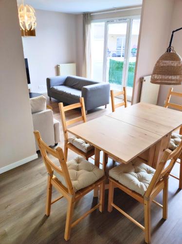 un salon avec une table et des chaises en bois dans l'établissement Magnific Appartement 2BDR-6P -Near Paris, à Aubervilliers
