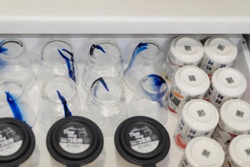 a shelf filled with empty glass jars with blue handles at Naha Airport, beaches, shopping centers are nearby #NewVilla in Itoman
