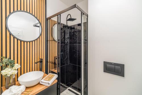 łazienka z prysznicem, umywalką i lustrem w obiekcie Prądnik Czerwony Studio - Balcony, City View - by Rentujemy w Krakowie