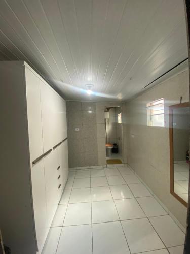 a bathroom with white cabinets and a tile floor at Casa in Garanhuns