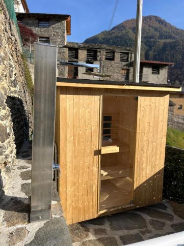 a wooden building with a door and a pole at Chalet Letizia Mountain and Relax - Your Mountain Holiday in Premana