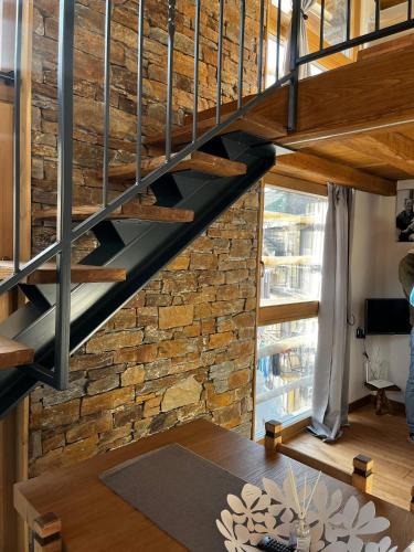 a staircase in a room with a brick wall at Chalet Letizia Mountain and Relax - Your Mountain Holiday in Premana