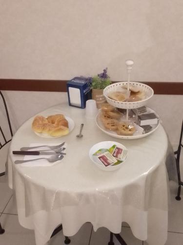 een tafel met een witte tafeldoek met voedsel erop bij Agorà sulla via dei Templi in Agrigento