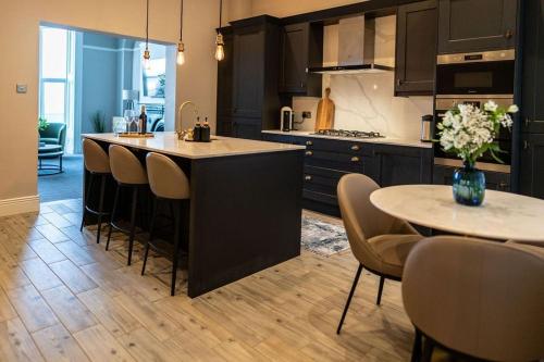a kitchen with a island and a table and chairs at King's Seafront Place in Cullercoats