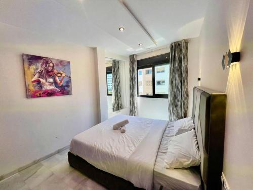 a bedroom with a bed and a painting on the wall at Jungle Vibes Stay - 2 BR Beach Front & Balcony in Tangier