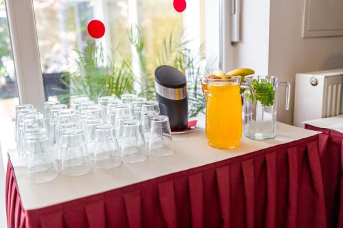 a table with glasses and a pitcher of orange juice at Hotel Lion in Modřice