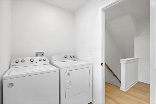 a white laundry room with a washer and dryer at The Golden Hour - Luxury and Rooftop Hot Tub in Columbus