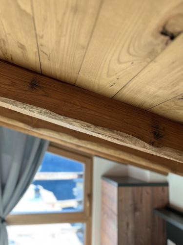 a wooden ceiling in a room with a window at Chalet Letizia Mountain and Relax - Your Mountain Holiday in Premana