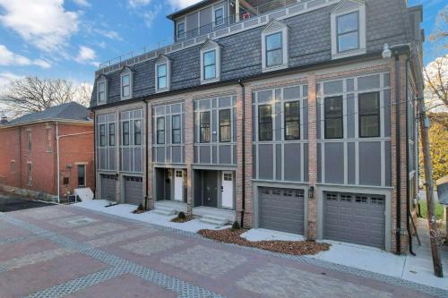 a building with two garage doors on a street at The Golden Hour - Luxury and Rooftop Hot Tub in Columbus