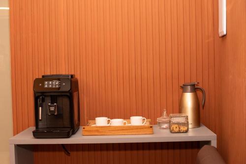a shelf with a coffee maker and cups on it at Pousada Princesa do Sertão in Piranhas