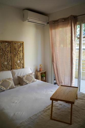 une chambre avec un grand lit blanc et une table dans l'établissement Cosy corner Paradise, à Villeneuve-Loubet