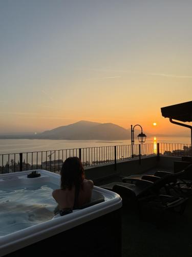 a woman sitting in a hot tub watching the sunset at Terrazza sulle mura Appartamento Sole in Predore