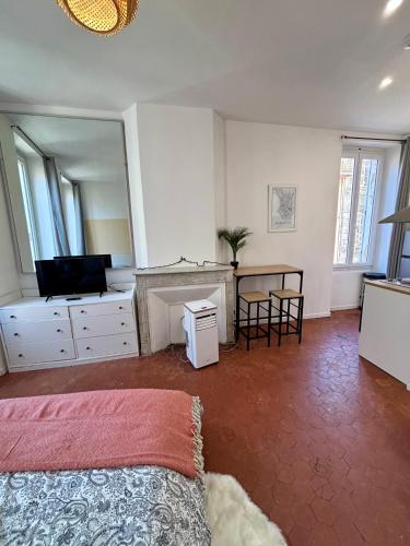 une chambre avec un lit, un bureau et une table dans l'établissement L'escapade marseillaise, à Marseille