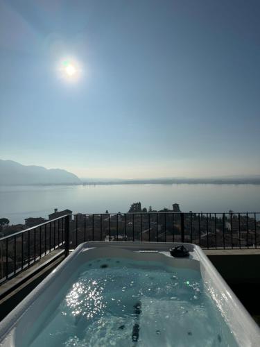 a hot tub on a balcony with a view of the water at Terrazza sulle mura Appartamento Sole in Predore