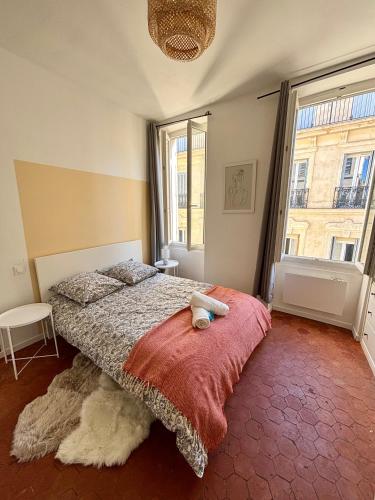 une chambre avec un lit et une grande fenêtre dans l'établissement L'escapade marseillaise, à Marseille