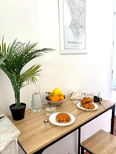 une table avec deux assiettes de nourriture et de fruits dans l'établissement L'escapade marseillaise, à Marseille