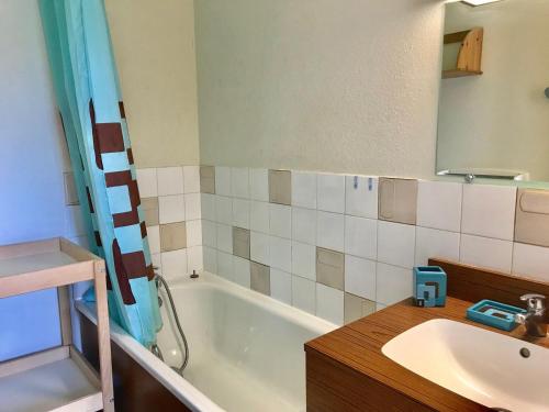 une salle de bain avec un lavabo et une baignoire dans l'établissement Appartement rénové avec balcon exposé plein sud, proche commerces et parking gratuit - FR-1-515-21, à Villard-de-Lans