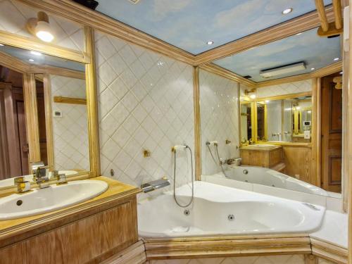 une grande salle de bain avec une baignoire et un lavabo dans l'établissement Appartement spacieux 4 étoiles, 4 pièces, sauna, au centre de Flaine Forêt, proche des pistes et commerces - FR-1-425-118, à Flaine