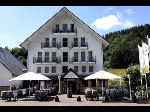 a large white building with tables and chairs and umbrellas at Smart Resorts B&B 1 BB1 201 in Winterberg