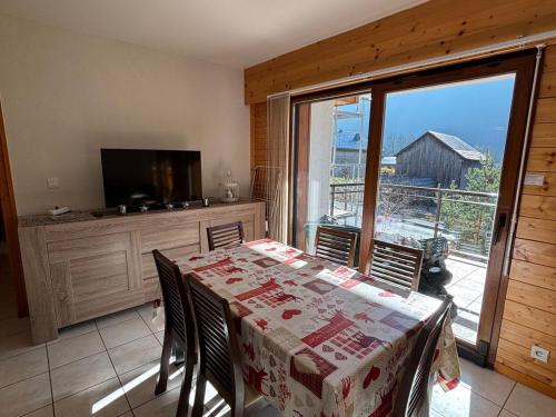une salle à manger avec une table et une grande fenêtre dans l'établissement Charmant 3 pièces au centre de La Chapelle-d’Abondance avec Multi Pass à 3€/jour/personne ! - FR-1-692-9, à La Chapelle-dʼAbondance