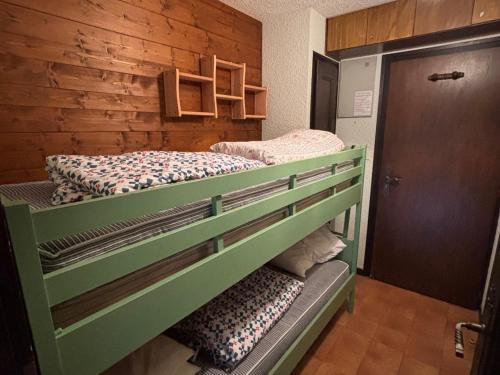 2 Etagenbetten in einem Zimmer mit einer Holzwand in der Unterkunft Studio près des pistes du Crêt Béni avec balcon - FR-1-692-67 in La Chapelle-dʼAbondance