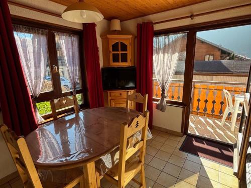 une salle à manger avec une table et des chaises et un balcon dans l'établissement Multi Pass 3€/jour/pers - Charmant 2P au centre du village, 6 pers, balcon sud, parking, non fumeur - FR-1-692-27, à La Chapelle-dʼAbondance