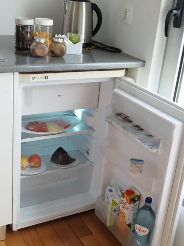 a refrigerator with its door open with food inside at Lofts Azul Pastel in Horta