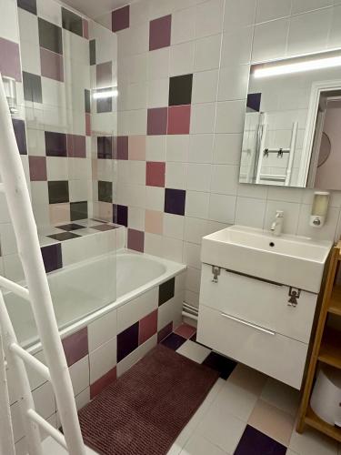 une salle de bain avec une baignoire blanche et un lavabo dans l'établissement Appartement 5 personnes Léon Frot PARIS, à Paris