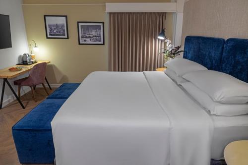 a hotel room with a large bed and a desk at Faranda Collection Cali, a member of Radisson Individuals in Cali