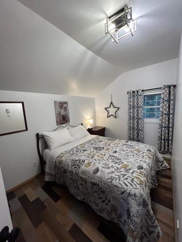 a bedroom with a large bed and a window at Aux Pignons Rouges Camping & Chalets in Saint Romain