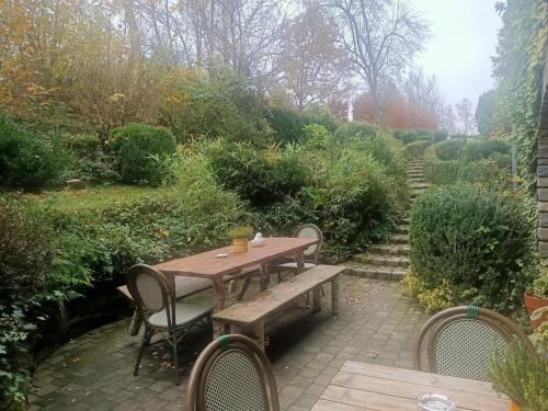 a wooden table and chairs in a garden at Dri les Courtils in La Roche-en-Ardenne