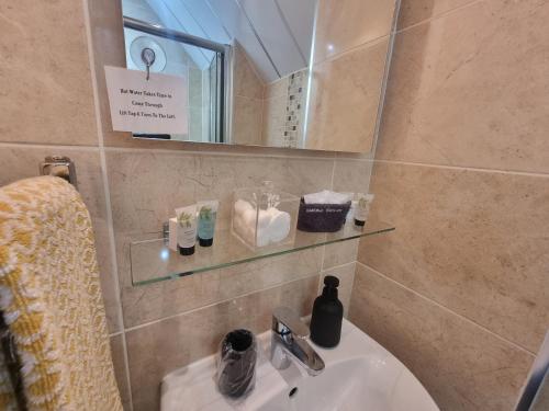 a bathroom with a sink and a mirror and a sink at St Leonards Guest House in Largs